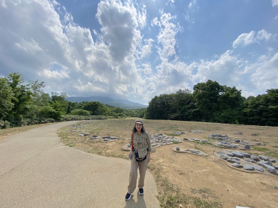 大森勝山遺跡に立つ監修者の鶴岡真弓氏 (撮影：大友真希)